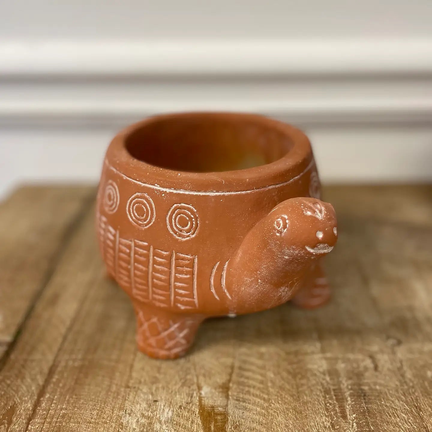 cement terra cotta colored planter shaped like turtle with cream colored pattern