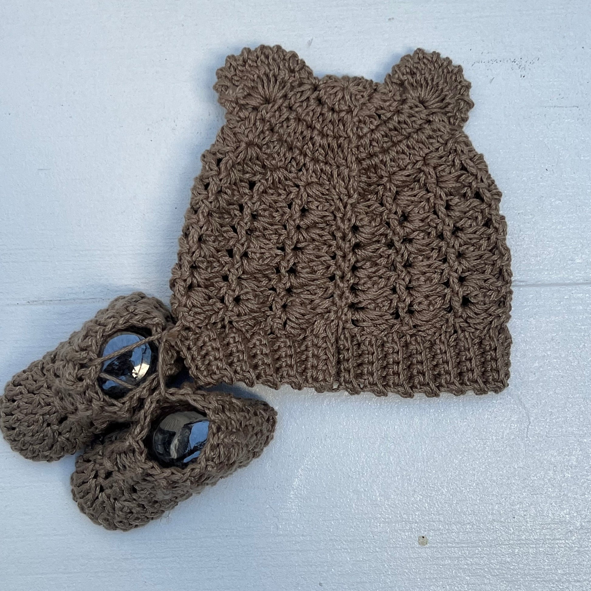 brown hand knit baby hat with small ears and booties