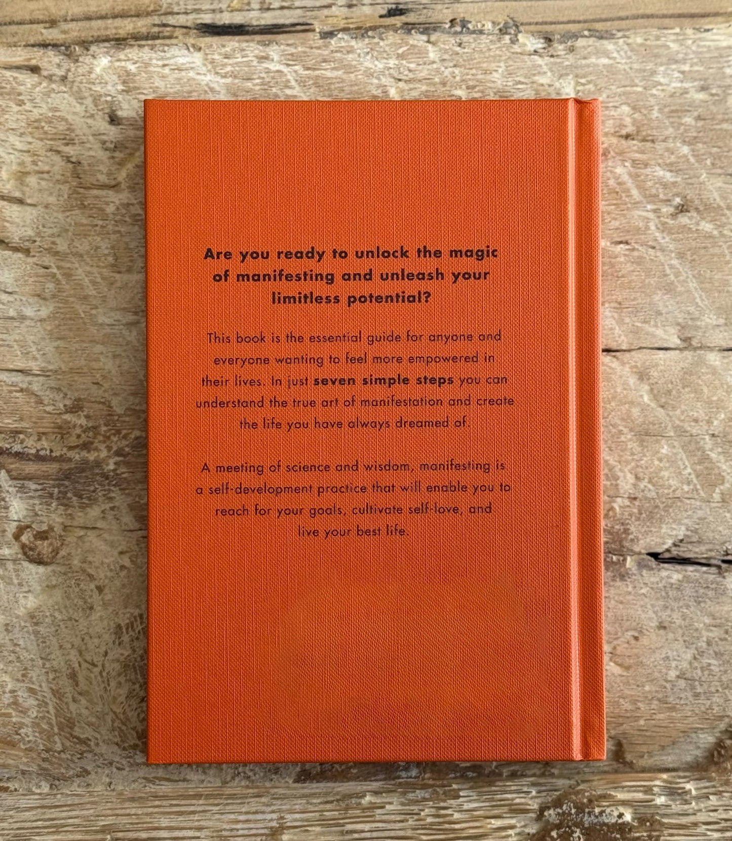 Orange book with text on a wooden surface