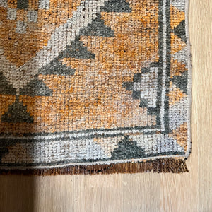vintage runner rug with orange, rust, dark gray and off white colors with geometric pattern