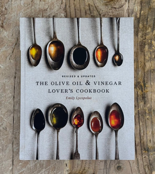 Cookbook titled 'The Olive Oil & Vinegar Lover's Cookbook' with images of spoons on a wooden surface.