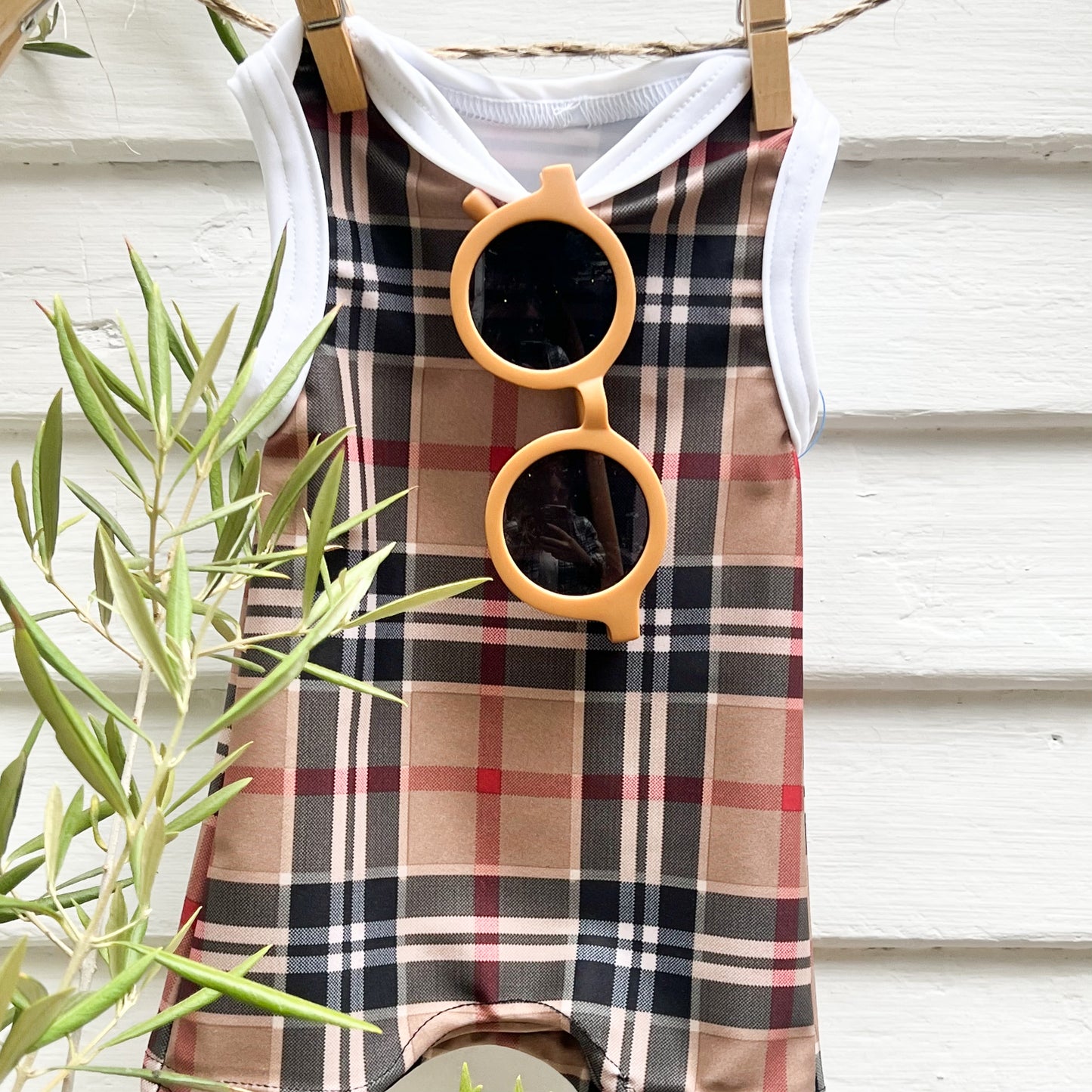 light brown toddler sunglasses hanging on a plaid retro toddlers swimsuit