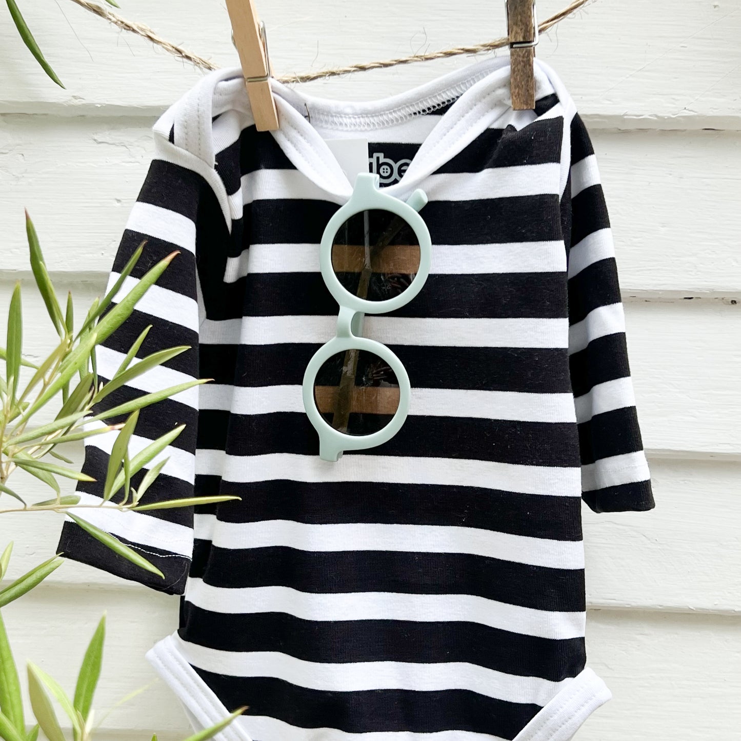 light blue toddler sunglasses hanging on a black and white striped long sleeve baby retro swimsuit