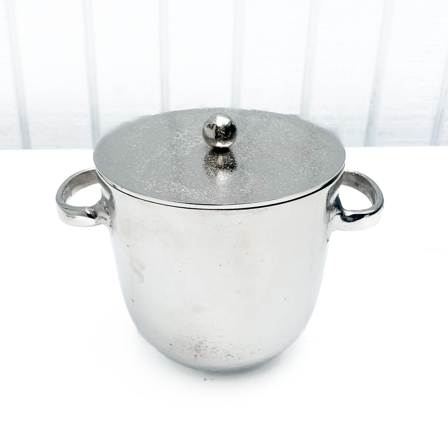 silver metal ice bucket with two handles and a lid