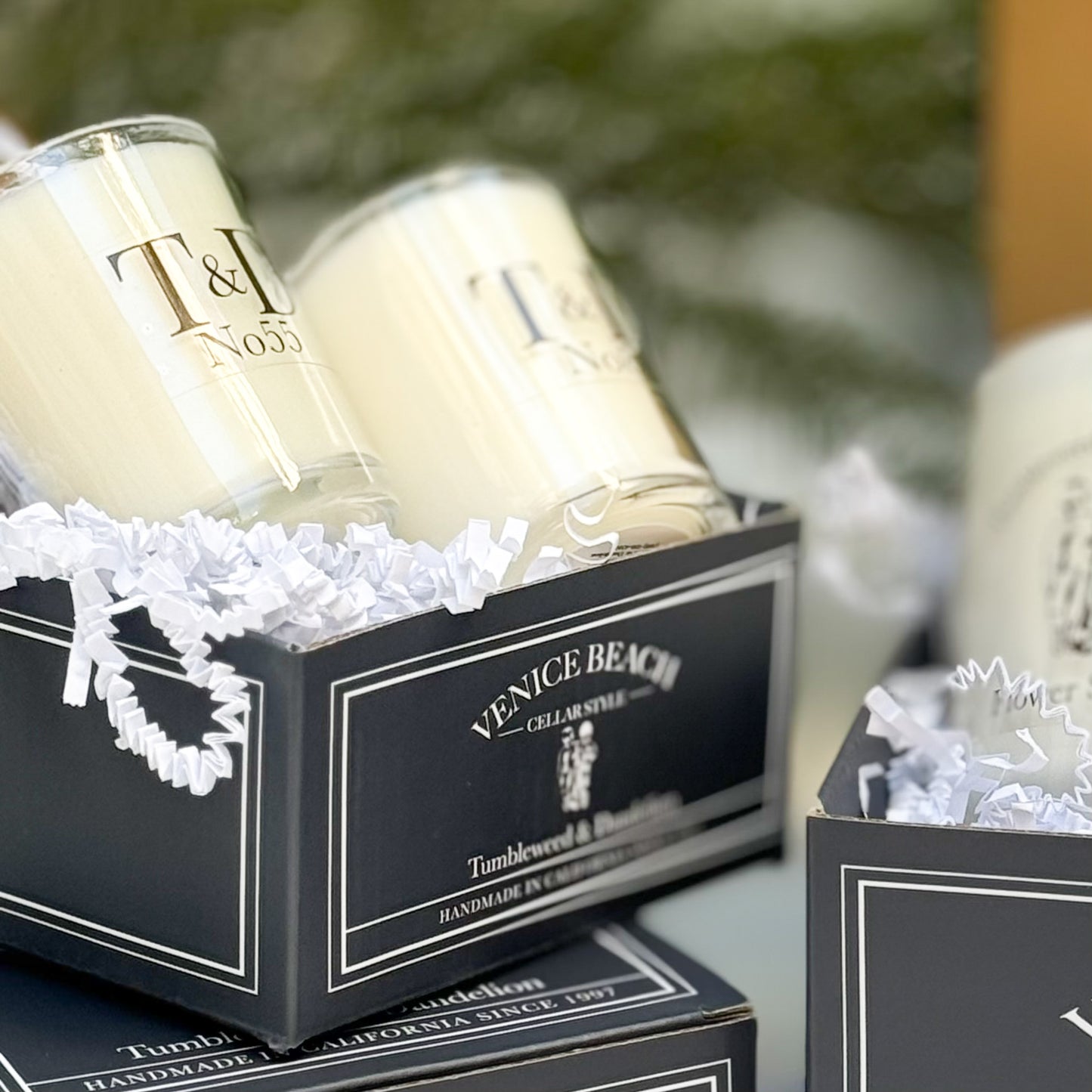 clear glass votive candles sitting in logo box with raffia
