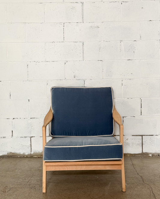 Chair with blue cushions against a white brick wall