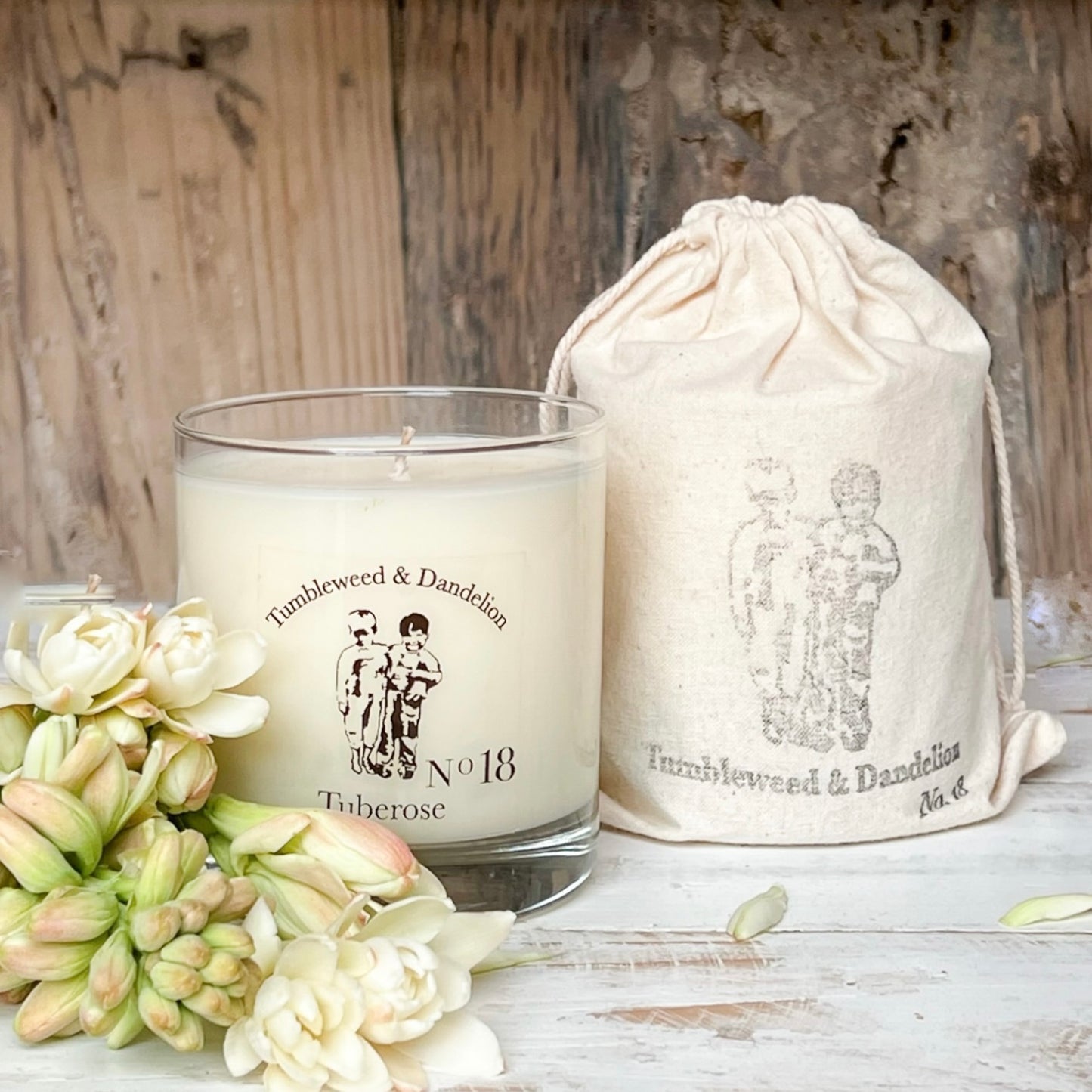 tuberose scented clear glass candle with Tumbleweed and Dandelion logo in black