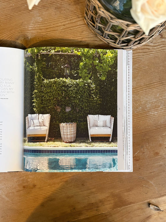 Open book showing an image of two chairs by a pool with a wooden frame.
