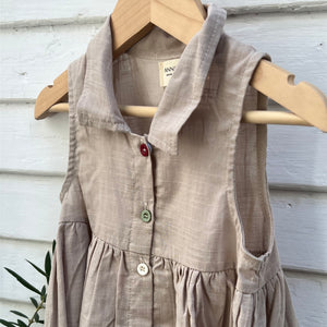 sleeveless tan linen kid's dress with colored buttons down front and a collar
