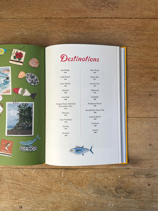 Open book on a wooden surface with 'Destinations' section and travel-themed stickers.