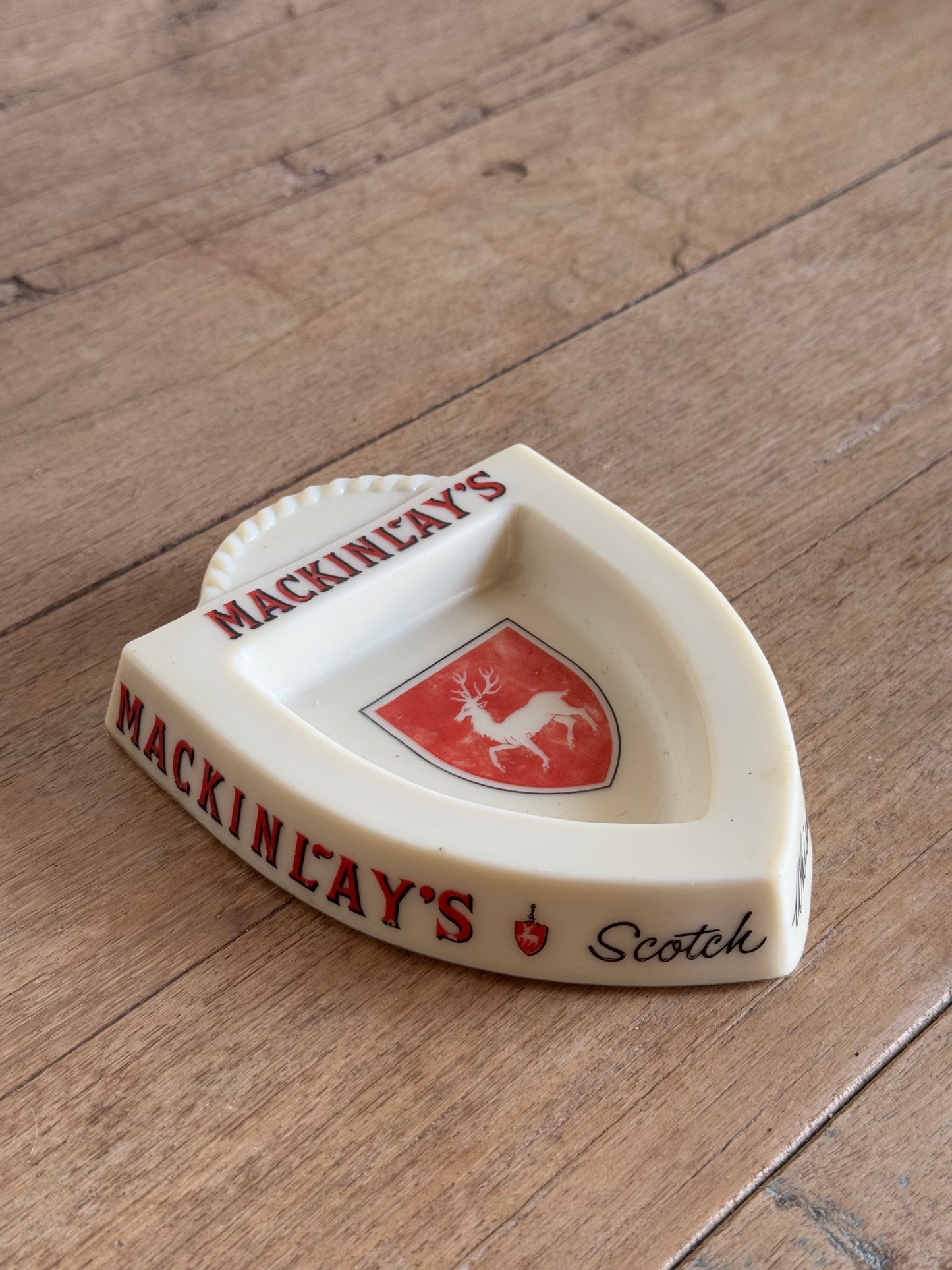 White Wedge-shaped container with red and black branding on a wooden surface