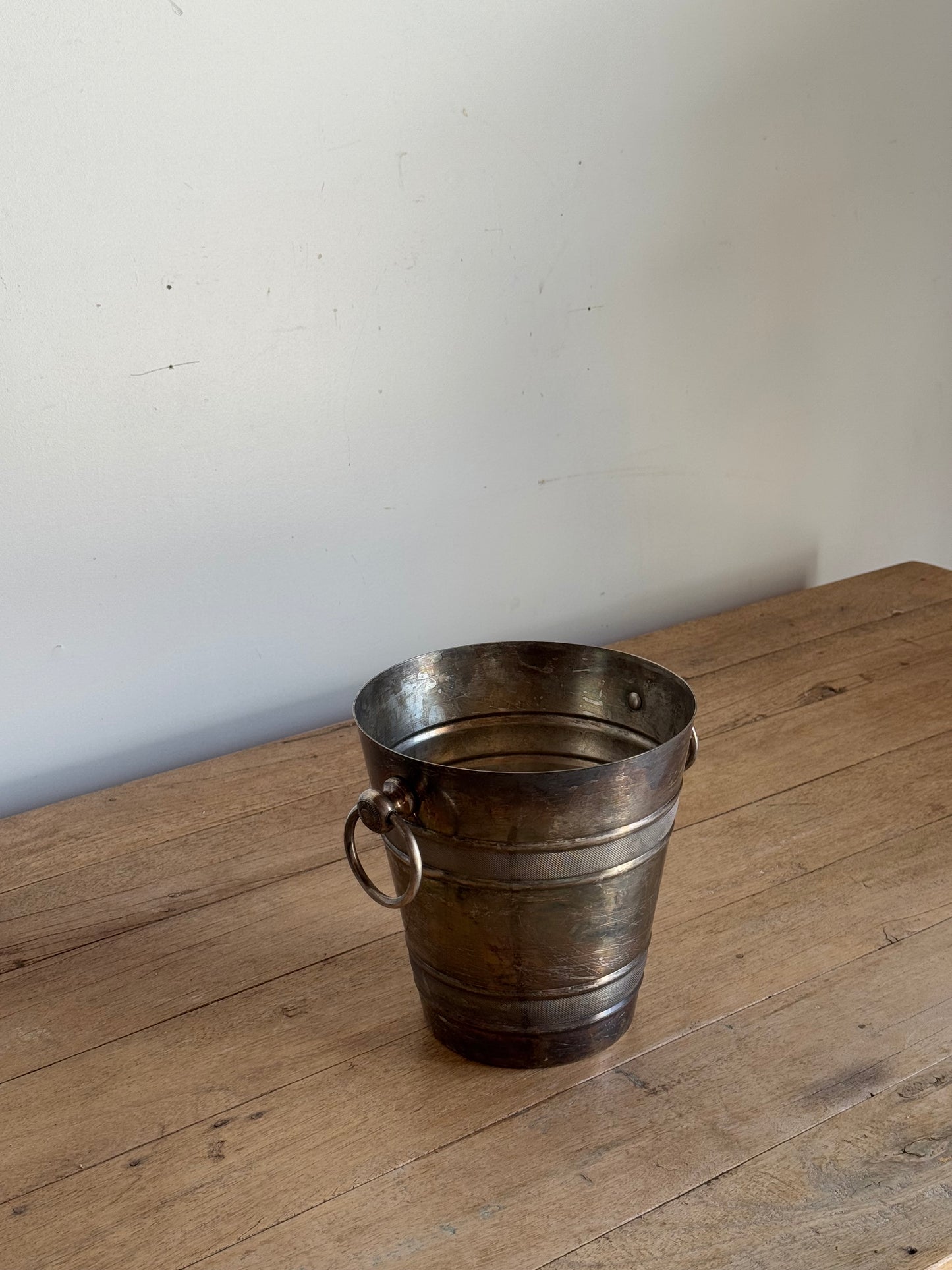 Metallic bucket on a wooden surface with a white background