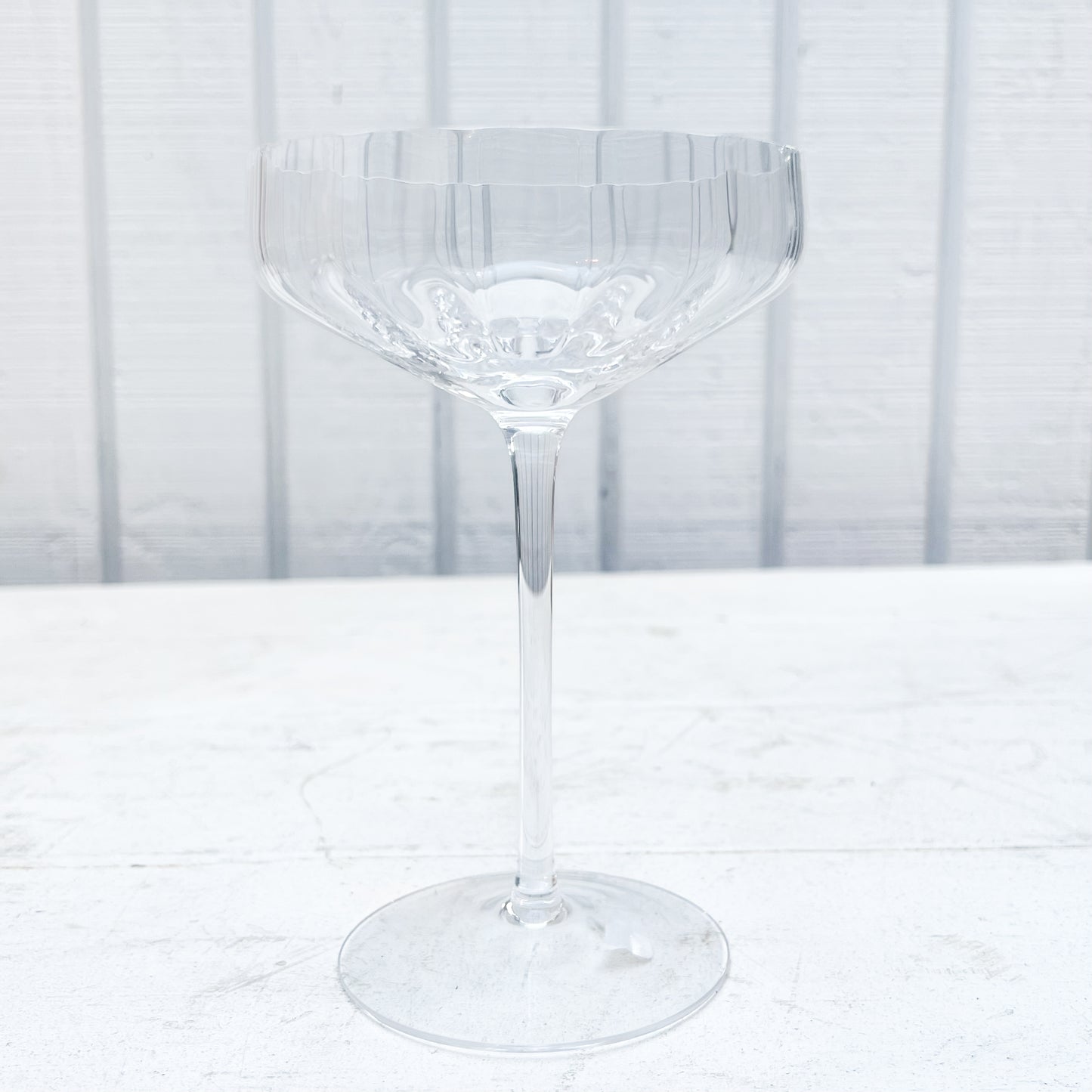 clear coupe shaped champagne glass with ridges