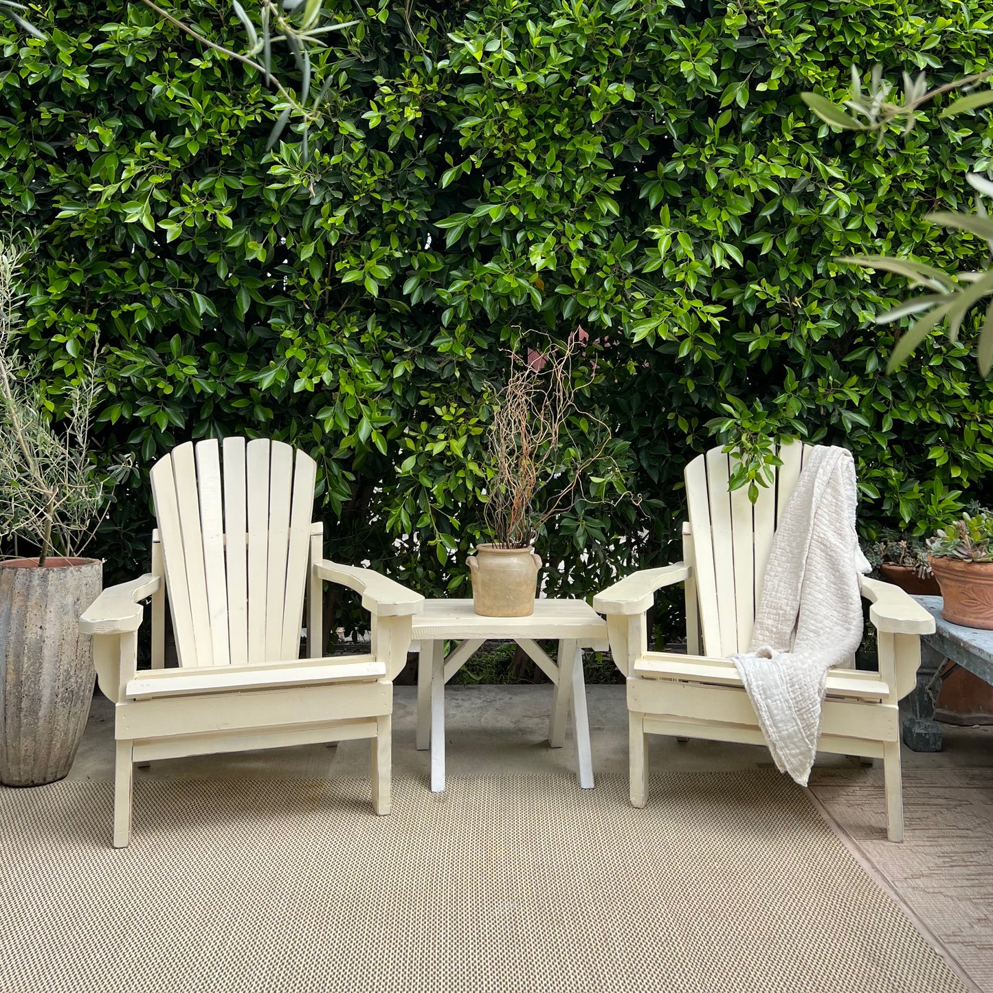 cream colored painted Adirondack chairs and side table