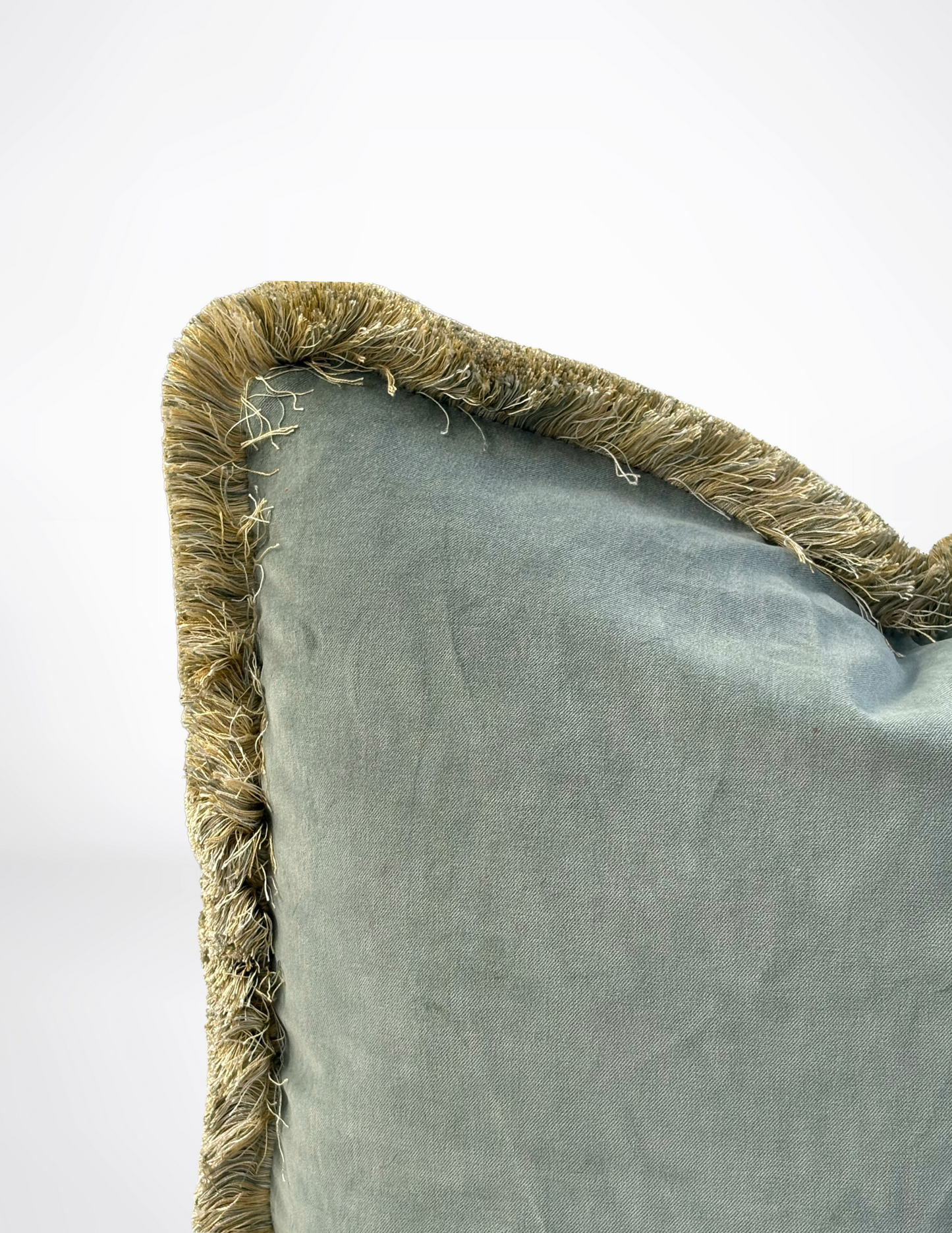 sage green pillow with textured brown trim on a white background