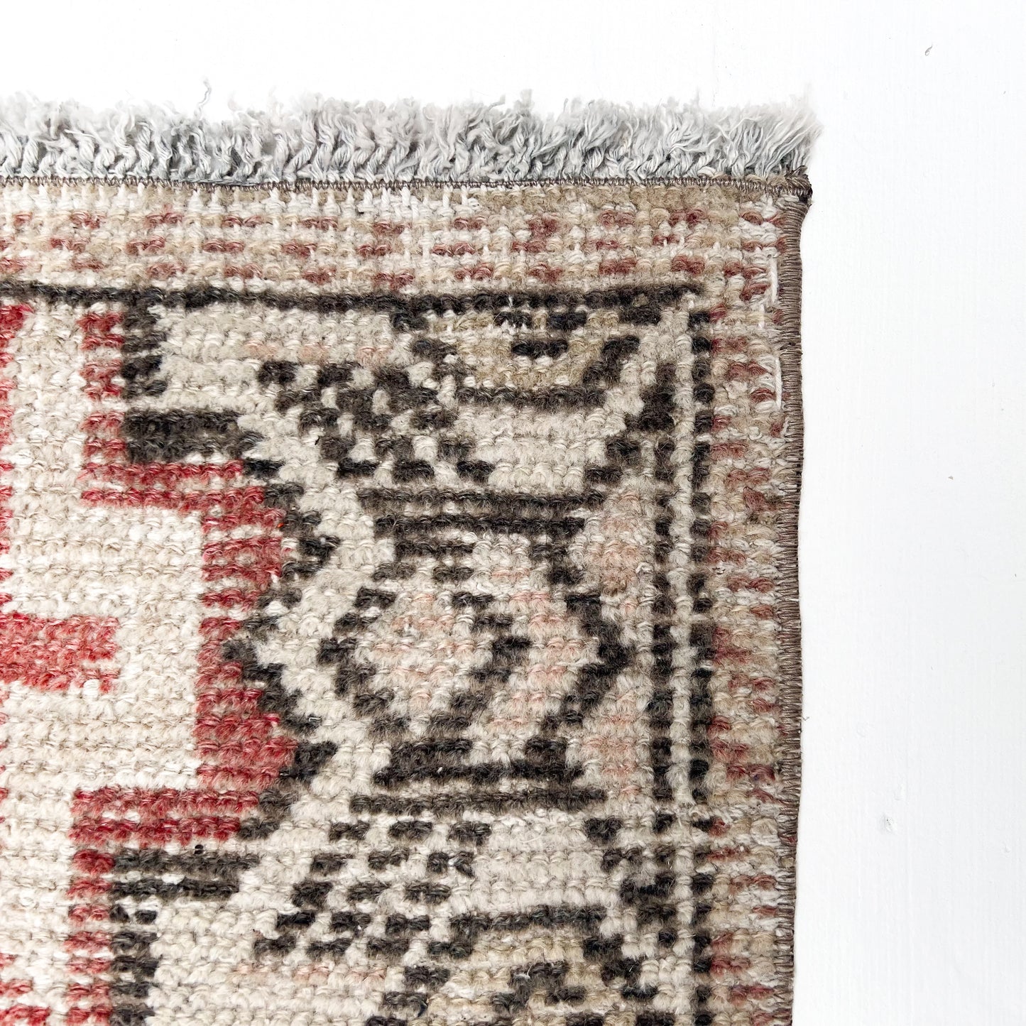 brick red, cream, gold, tan and black colored small Turkish rug
