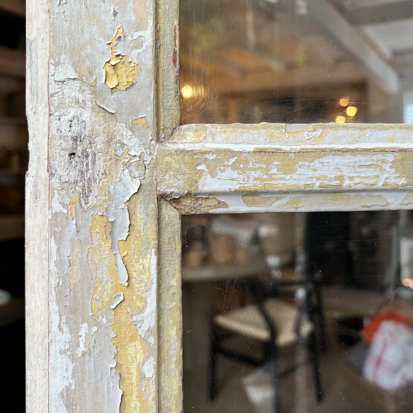 rustic hutch of old wood with distressed butter yellow paint finish, glass doors on top and bottom