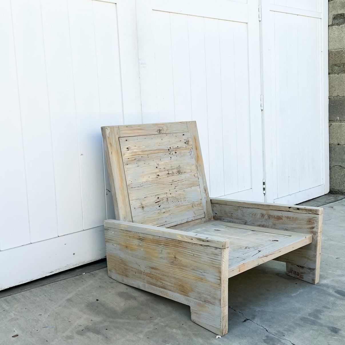 wood outdoor armless lounge chair with white cushions