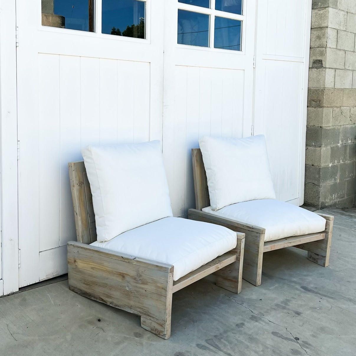 wood outdoor armless lounge chair with white cushions