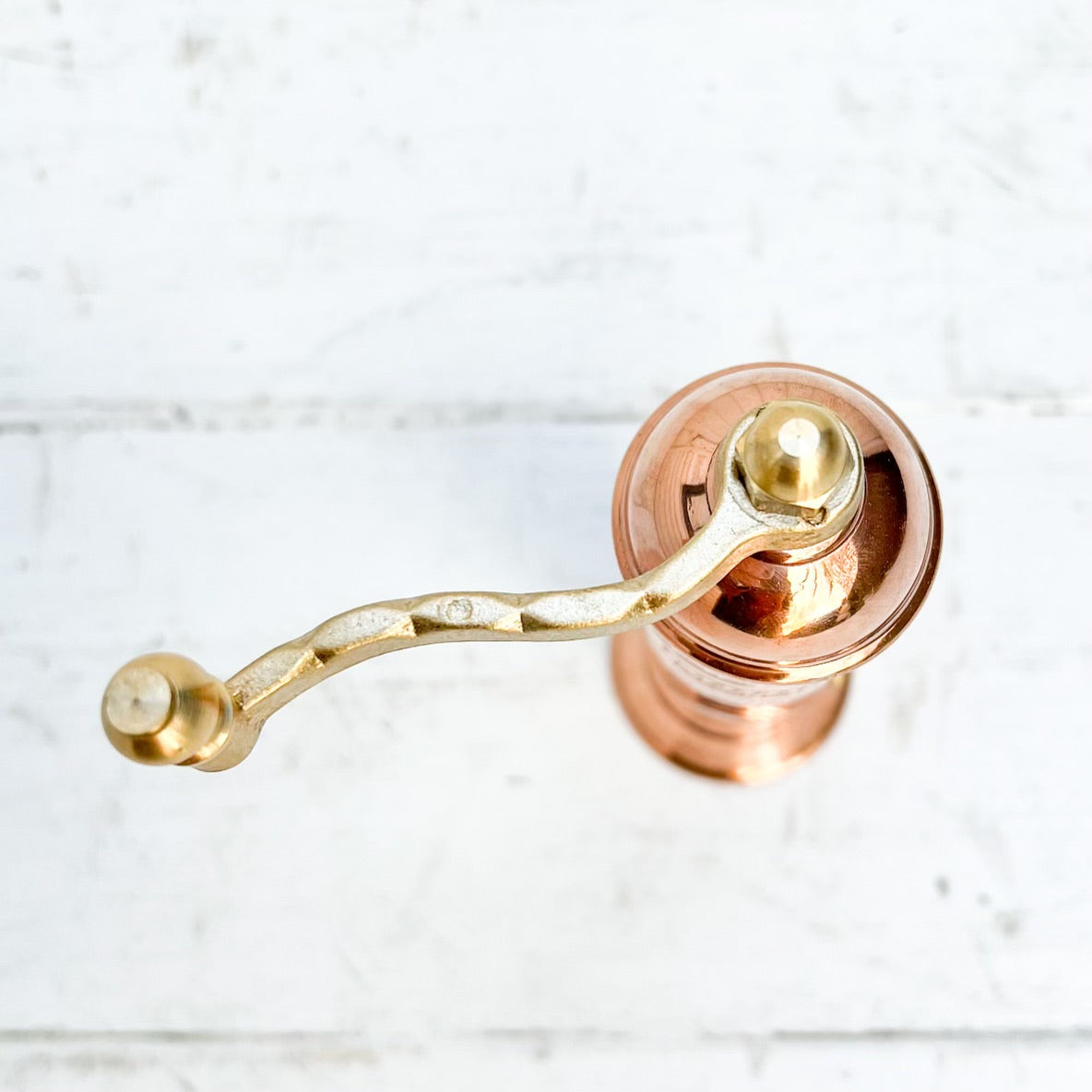 copper salt and pepper grinder with brass crank handles on the top