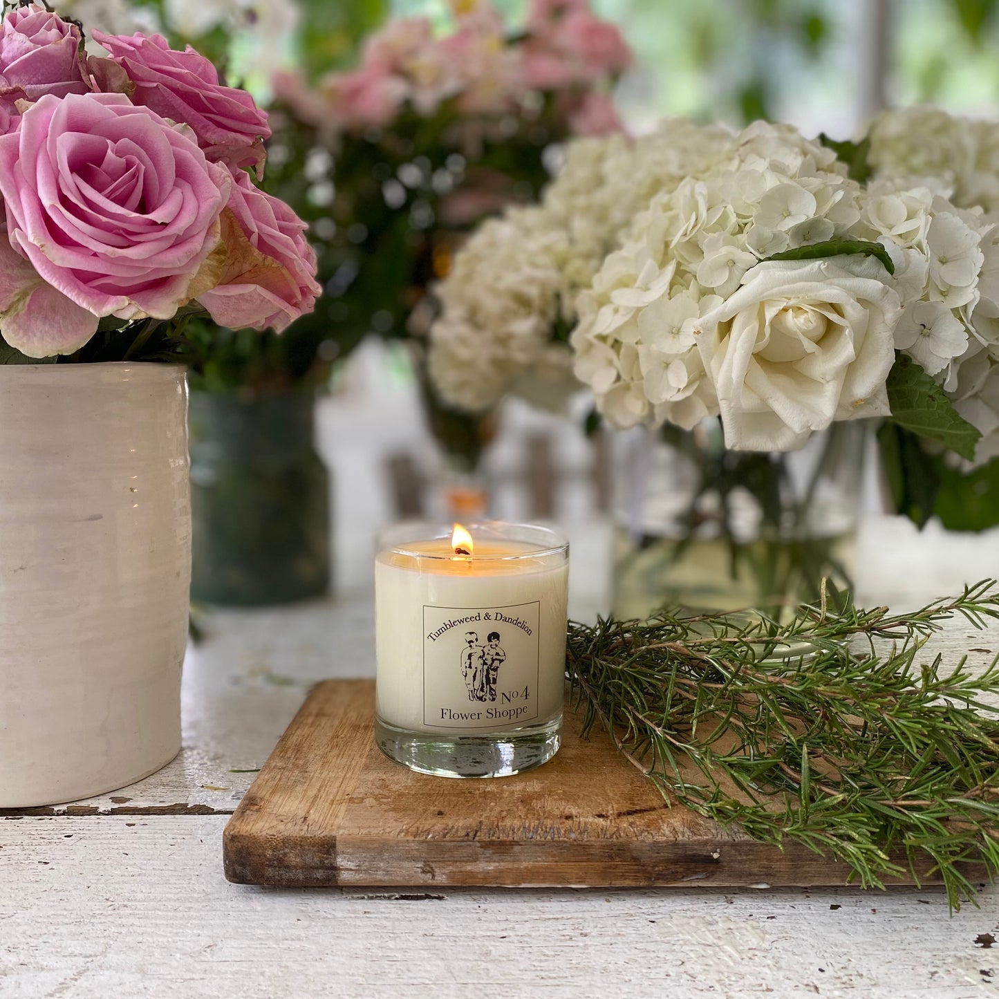 clear glass candle with black and clear Tumbleweed logo label, flower shoppe scented