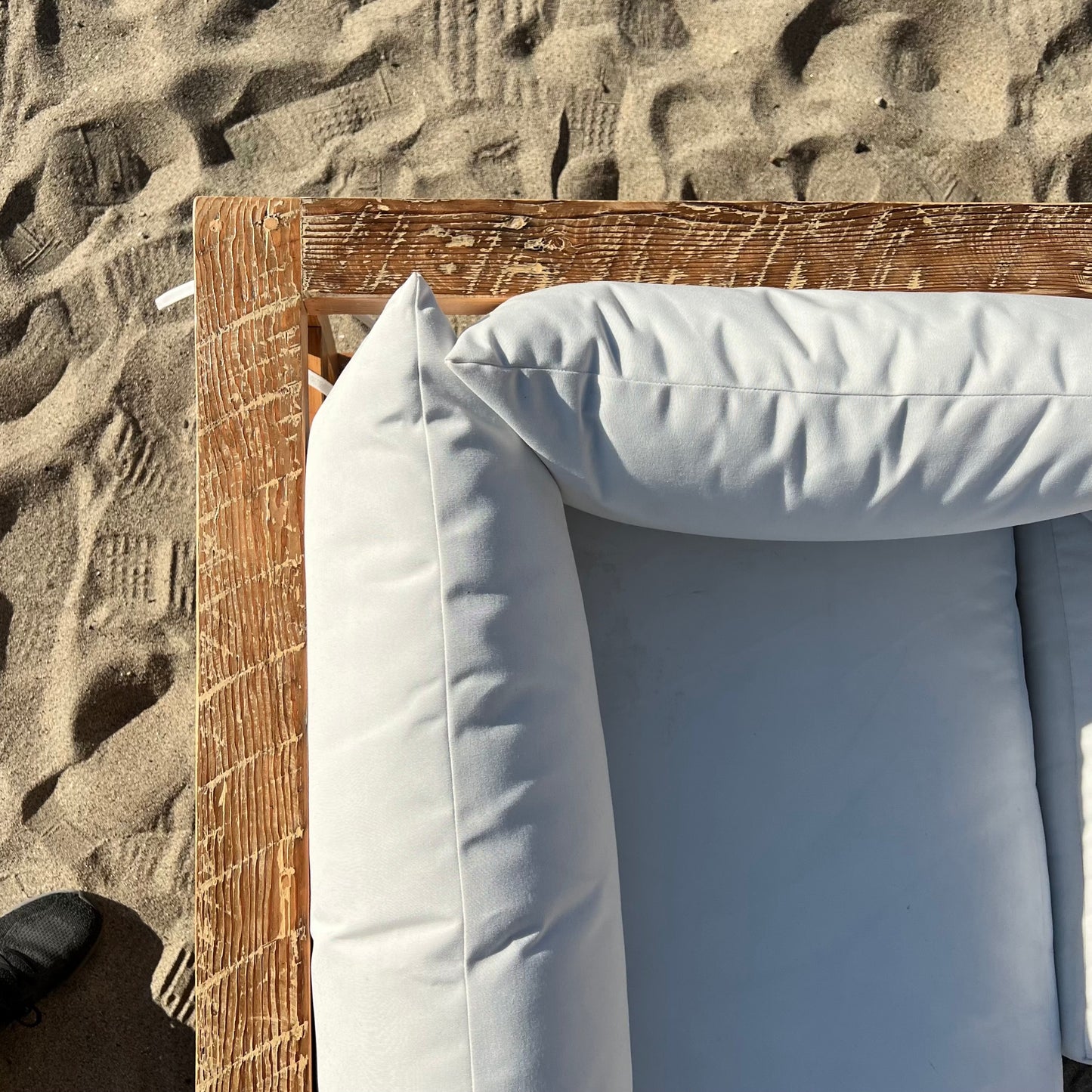 sectional sofa made of repurposed wood, off white cushions with outdoor fabric, medium brown wood color
