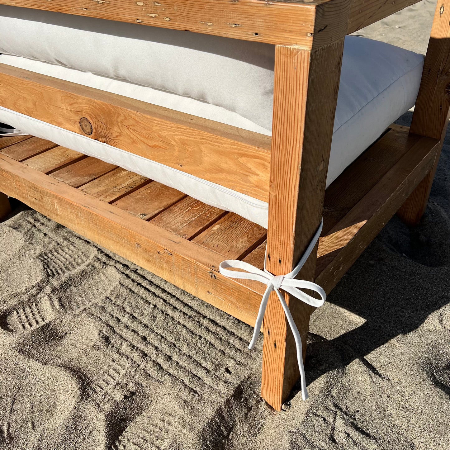 sectional sofa made of repurposed wood, off white cushions with outdoor fabric, medium brown wood color