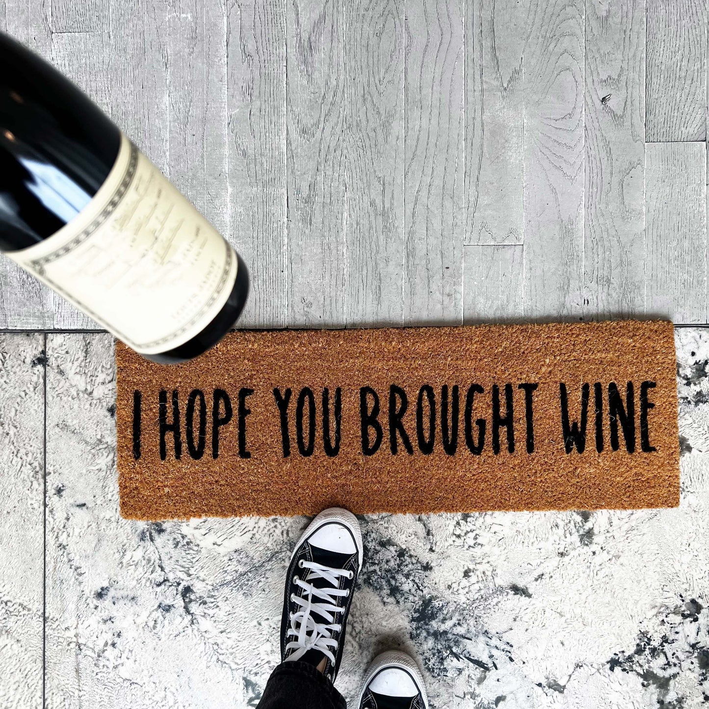 brown door mat that says I hope you brought wine