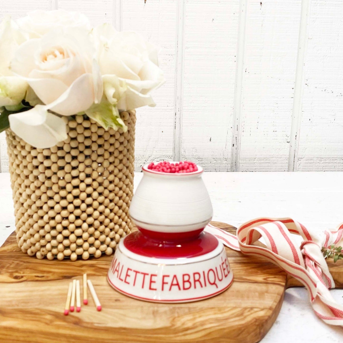 red and white ceramic match strike holder with red French wording