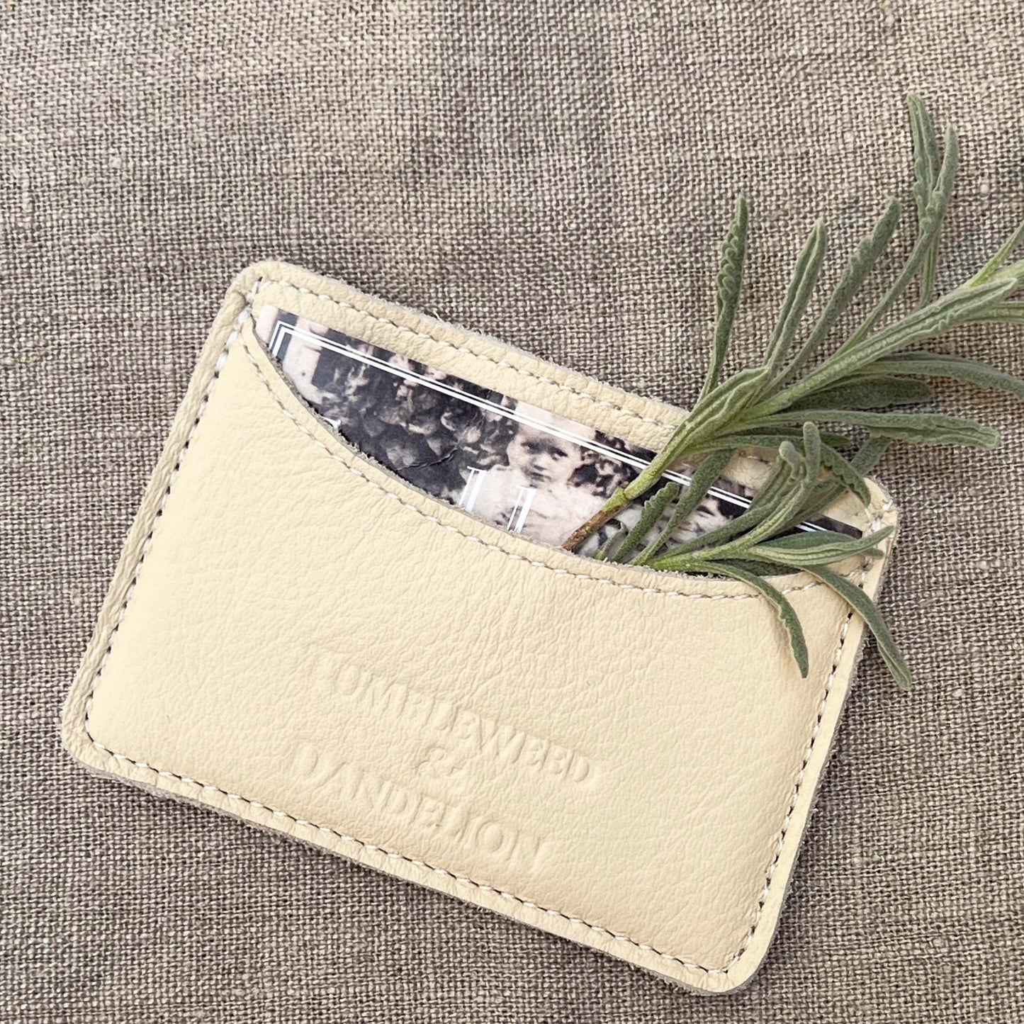 cream colored credit card holder with "Tumbleweed and Dandelion" imprinted