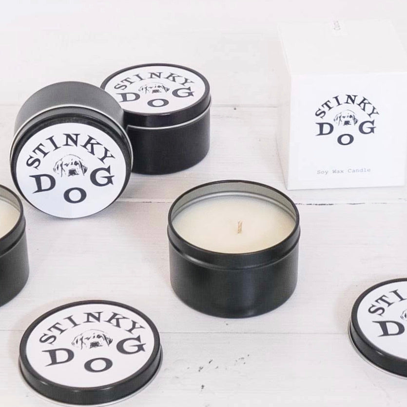black travel tin candle with black and white logo on lid
