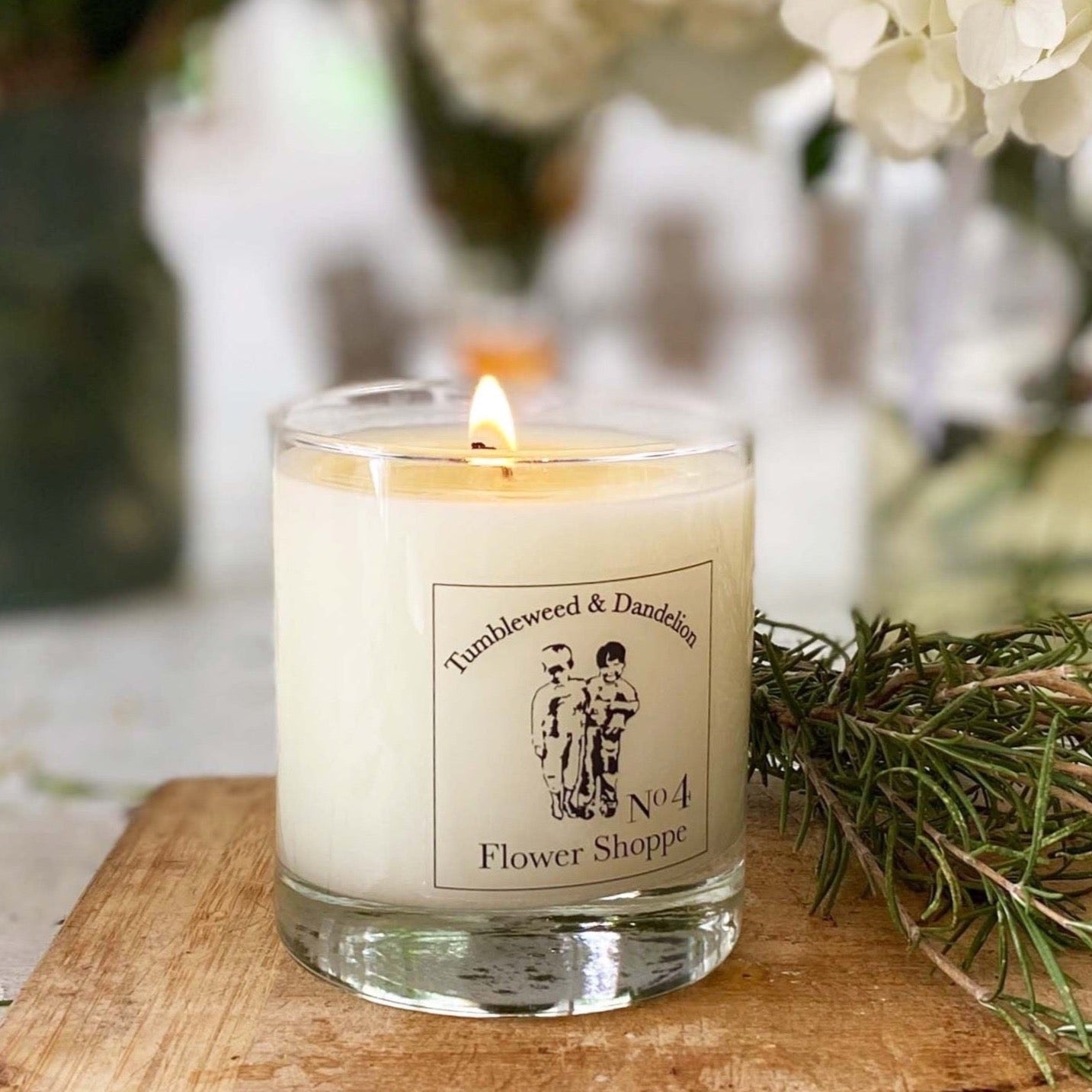 clear glass candle with black and clear Tumbleweed logo label, flower shoppe scented