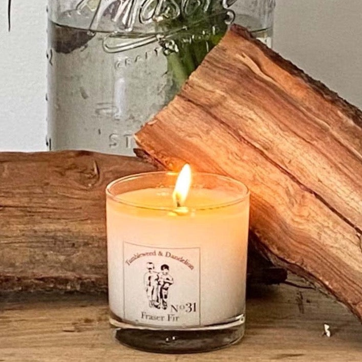 fraser fir scented clear glass candle with Tumbleweed and Dandelion logo in black