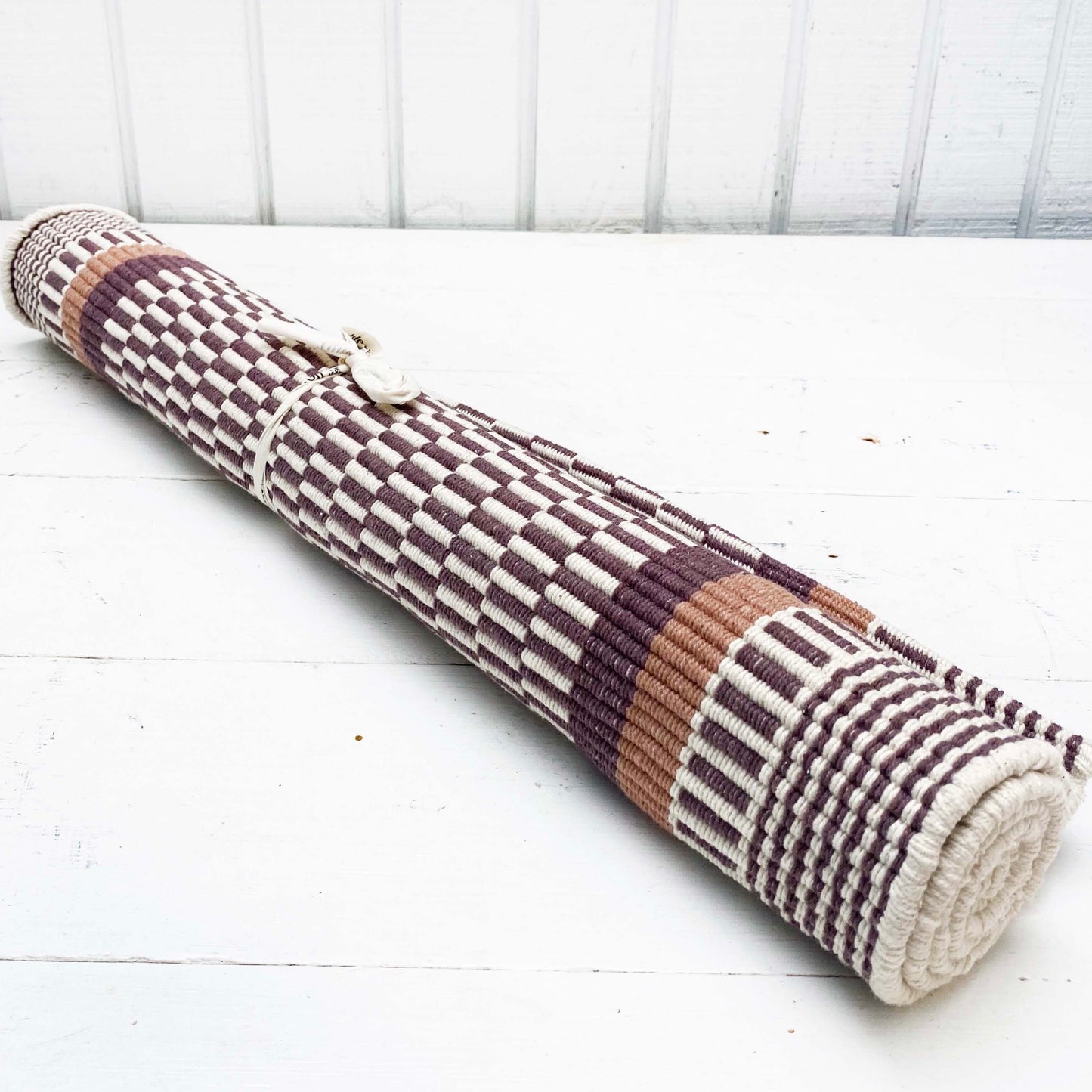 brown and white rug with brown and striped border