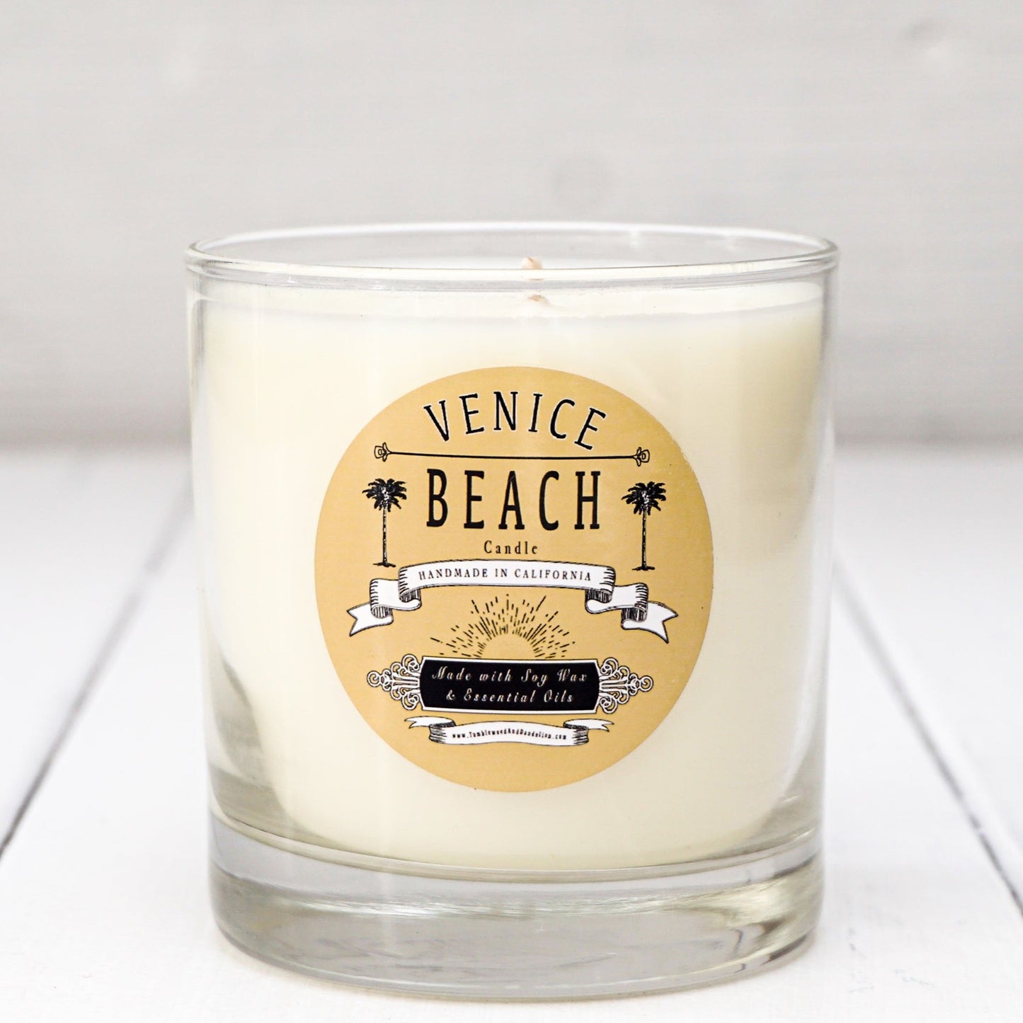 Clear glass candle with tan and black Venice Beach label