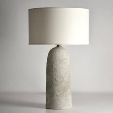 Load image into Gallery viewer, Table lamp with textured concrete base and white shade on a gray background