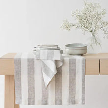 Load image into Gallery viewer, Table setting with striped table runner, bowls, and a vase with flowers on a light background
