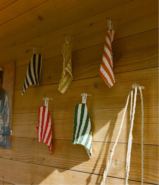 Towels hanging on a wooden wall with a person partially visible.