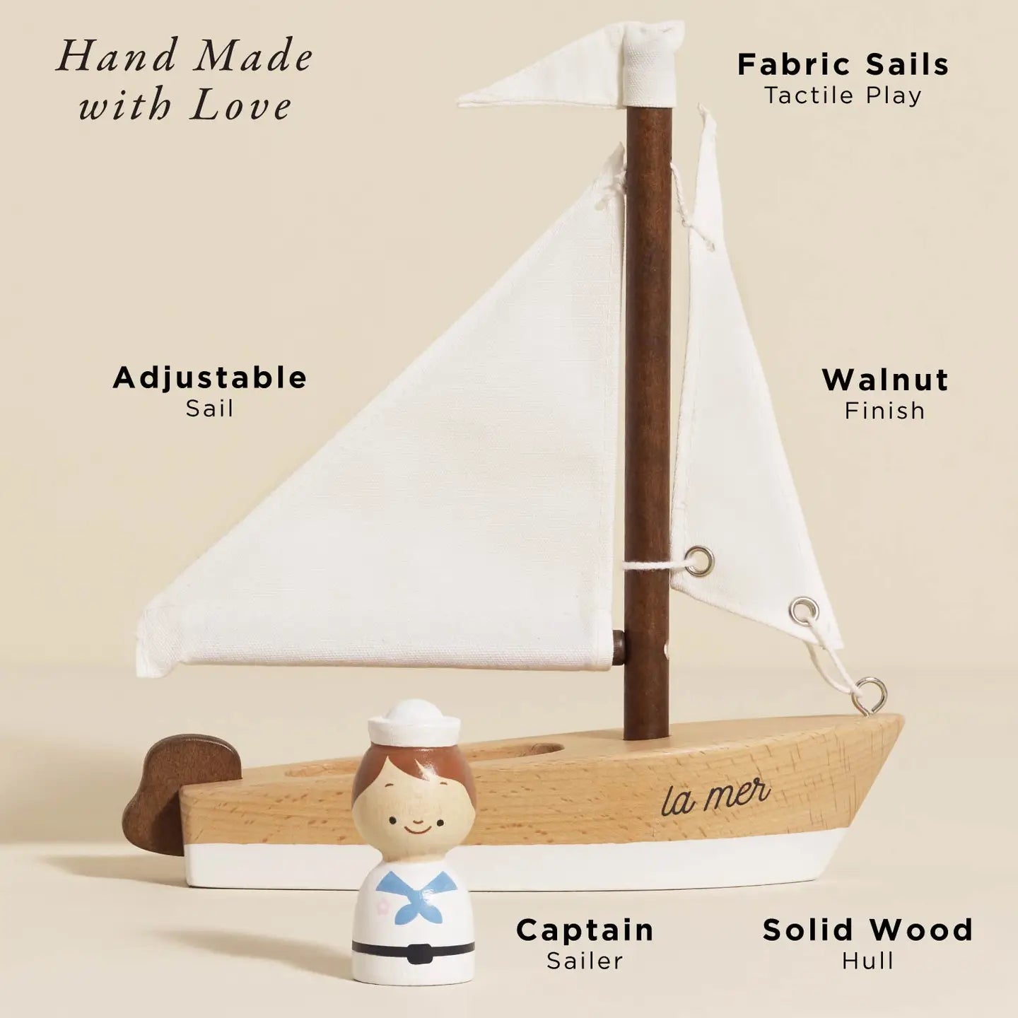 Wooden sailboat with fabric sails and a small figure of a sailor on a beige background
