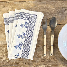 Load image into Gallery viewer, Set of white napkins with blue floral patterns on a wooden surface with cutlery.