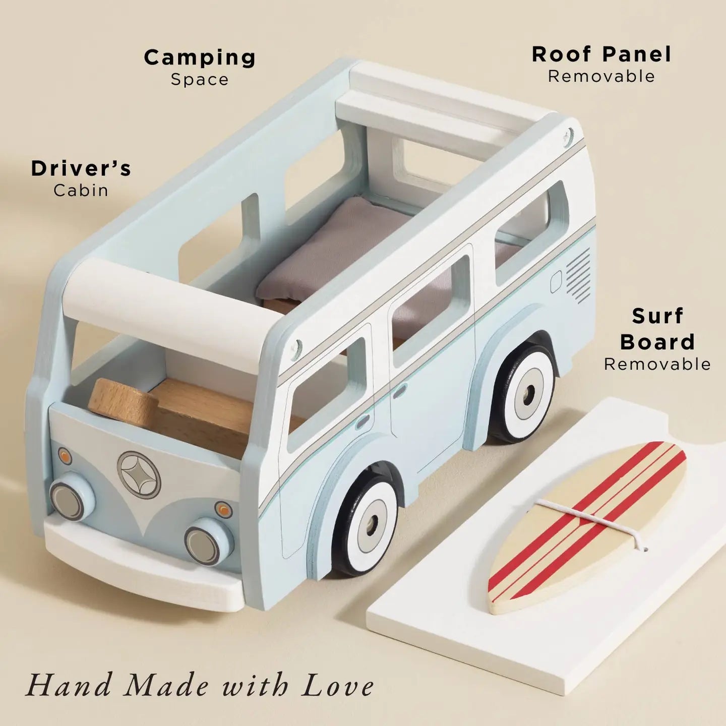 Toy camper van with removable roof panel and surfboard on a beige background