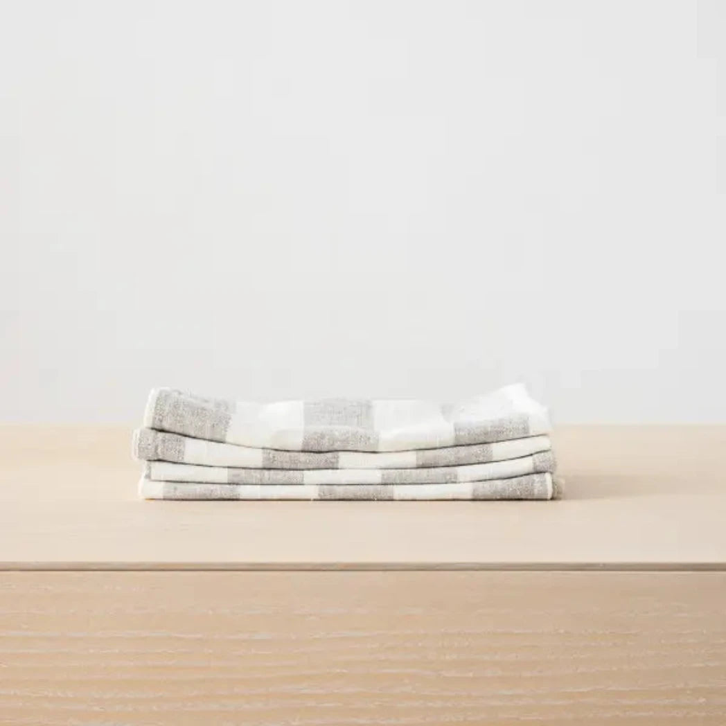 Stack of folded checkered towels on a beige surface with a light gray background