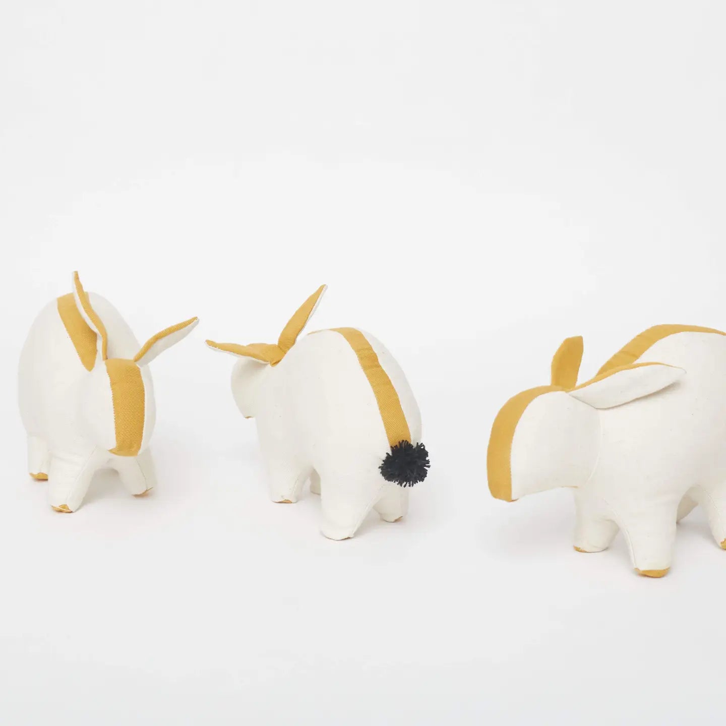 Three white and gold decorative animals on a light gray background
