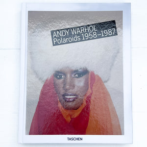 cover of book of Andy Warhol's Polaroids, with a picture of Grace Jones wearing a white furry hat and orange scarf