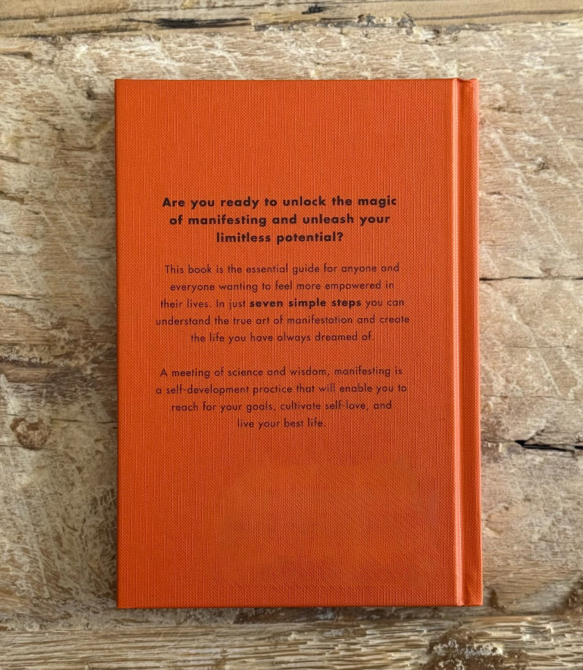 Orange book with text on a wooden surface