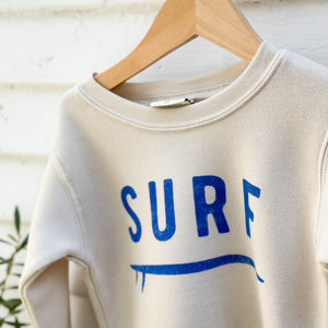 off white toddler sweatshirt with word SURF in blue on front