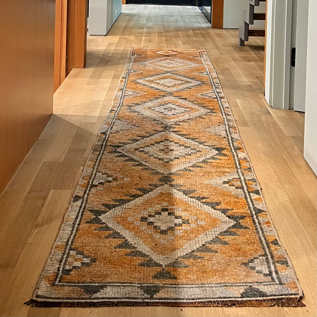 vintage runner rug with orange, rust, dark gray and off white colors with geometric pattern