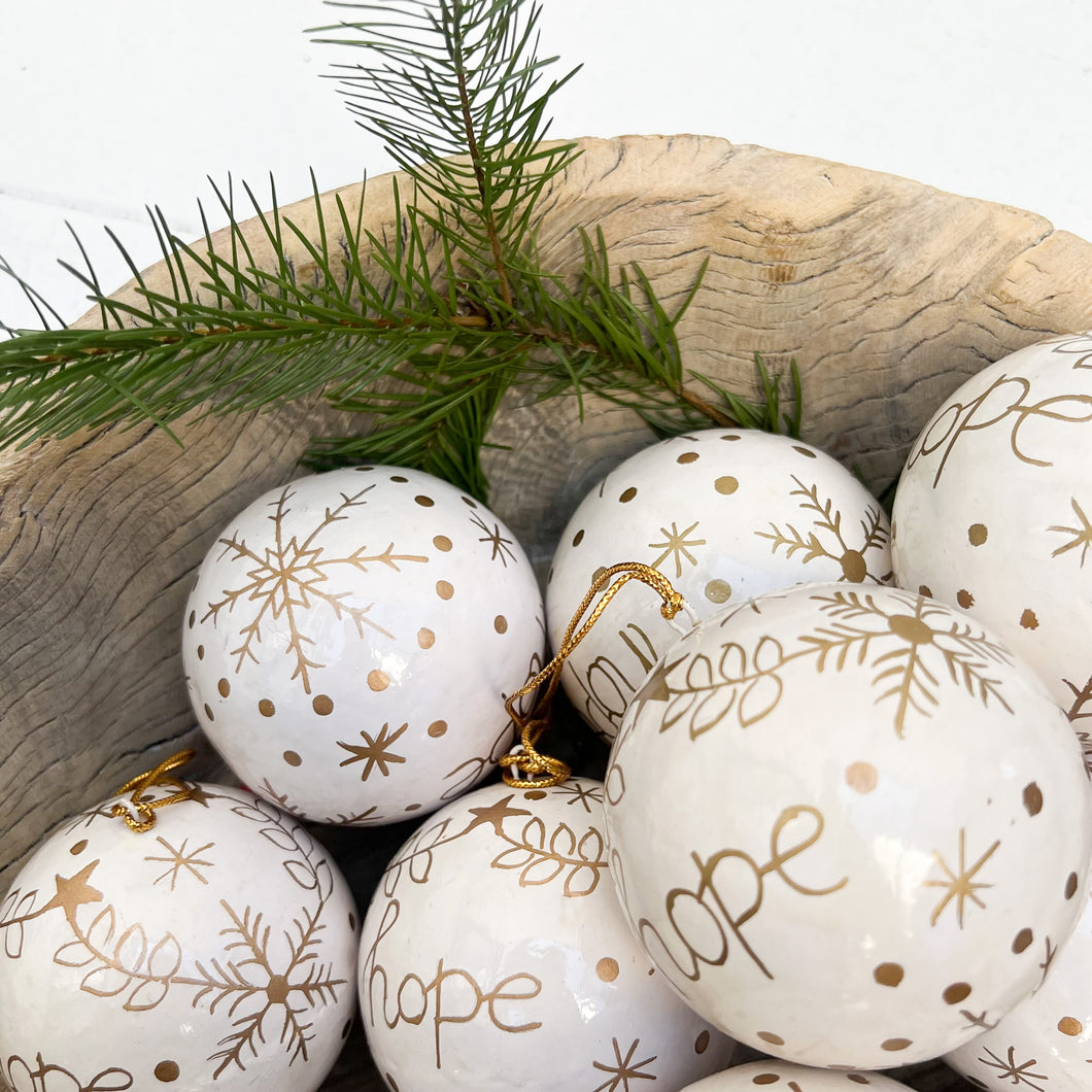 white paper mache round ornaments with gold decoration and word 