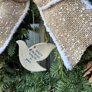 white ceramic dove ornament with words "imagine all of the people living life in peace" in blue