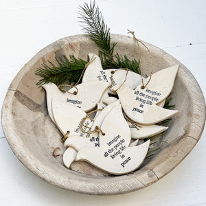 white ceramic dove ornament with words "imagine all of the people living life in peace" in blue